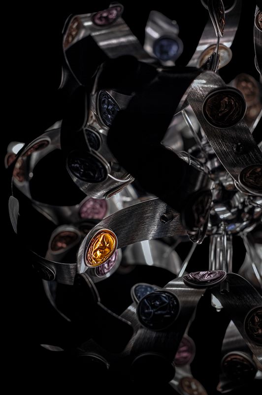 Kaffeekapseln, spiralförmig zu einer Skulptur gefügt, im dunklen Licht