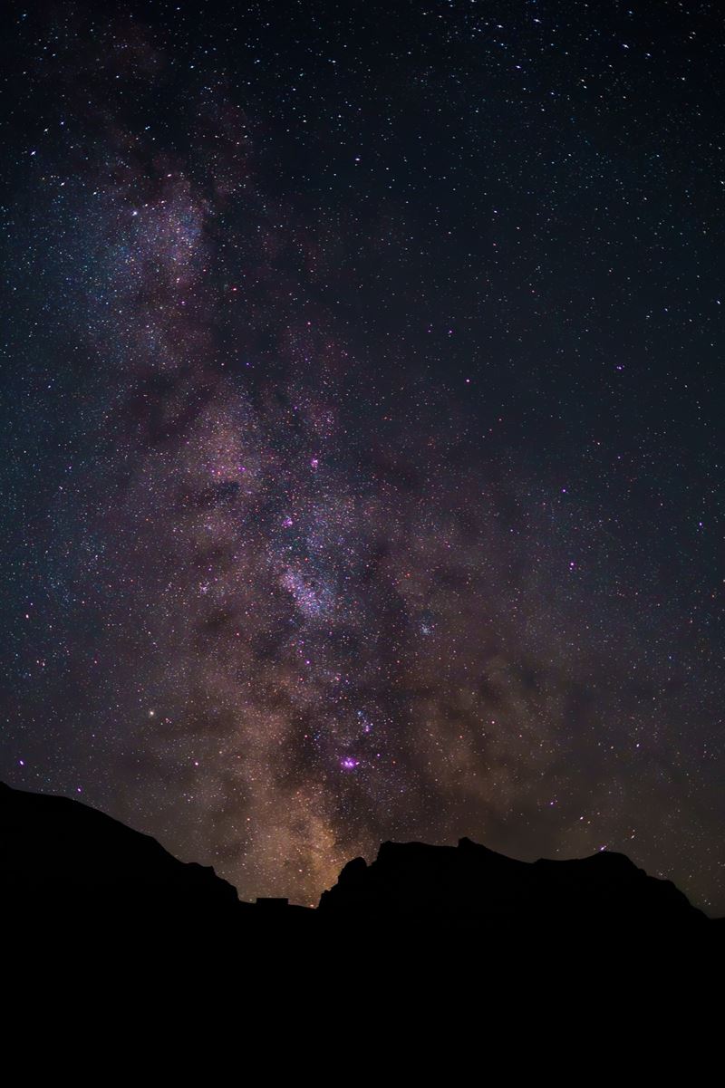 Milchstrasse über einer Bergsilhouette bei Nacht