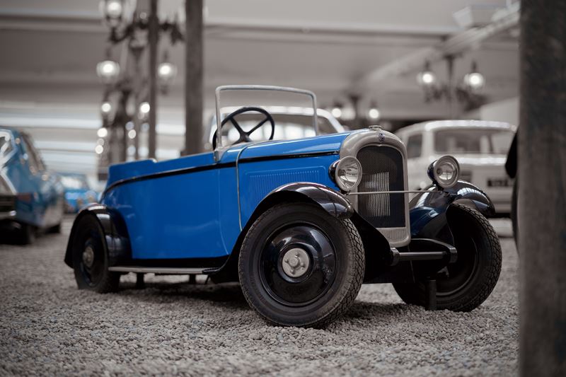 Kleiner blauer Oldtimer-Roadster in einer Fahrzeugausstellung